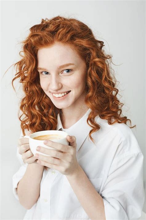 Portrait Of Tender Redhead Girl With Freckles Smiling Holding Cup Looking At Camera White