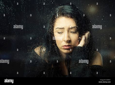 Sad Depressed Woman Looking Down Hand On Face Sitting At Rainy Window Closeup Cinematic Portrait