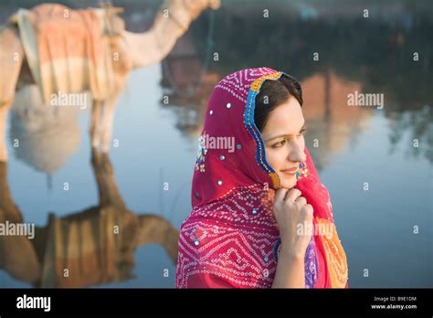 Woman With Reflection Of A Camel And A Mausoleum In The River Taj