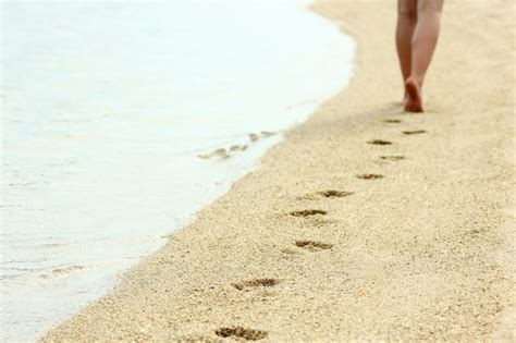 Ślady stóp na piasku na plaży latem Zdjęcie Premium