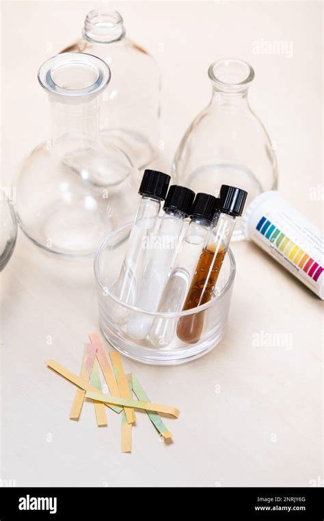 Test Tubes With Liquids And Solutions Flasks And Indicator Papers On