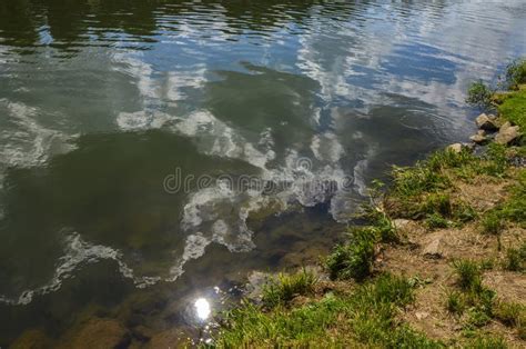 Abstract Reflection Of A Cloud On A River Water Surface Stock Photo