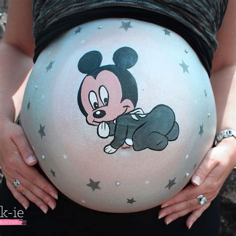 A Pregnant Woman Wearing Mickey Mouse Painted On Her Belly With Stars