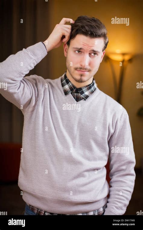 Confused Or Doubtful Young Man Scratching His Head And Looking Up