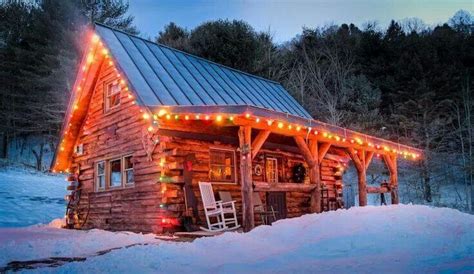 A Small Log Cabin With Christmas Lights On The Roof