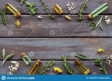 Aromatherapy Essential Oils Near Herbs And Leaves On Dark Wooden