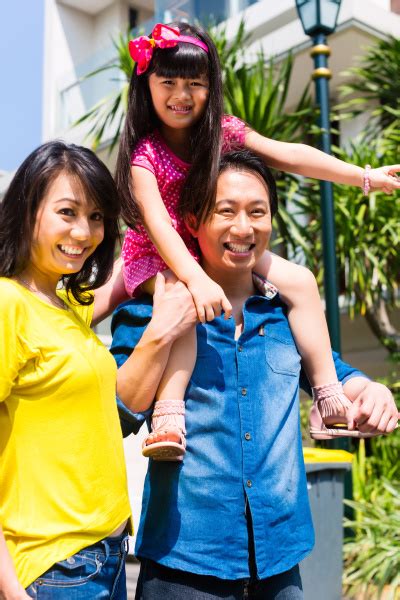 Asiatische Familie Mit Dem Kind Das Vor Haus Steht Stock Photo