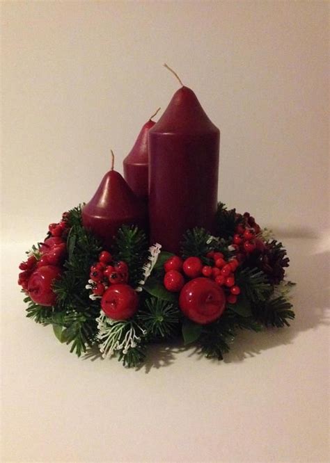 Two Red Candles Surrounded By Greenery And Berries