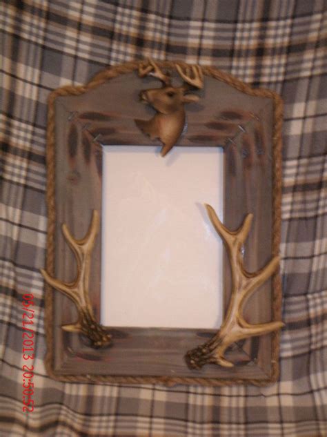 The Deer Antlers Are Mounted To The Wall In This Rustic Photo Frame