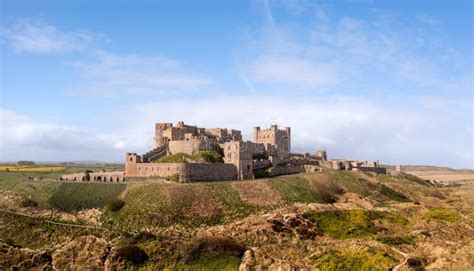 Aerial Panorama Landscape Of Bamburgh Castle And Sand Dunes In