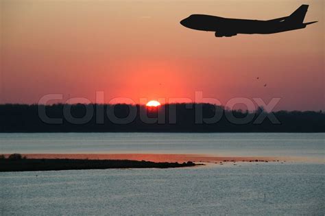 Solnedgang Og En Silhuet Af Fly Stock Foto Colourbox