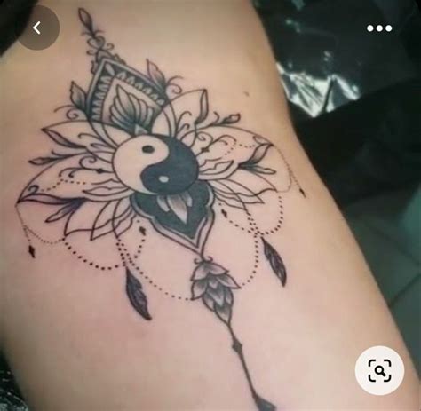 A Woman S Thigh With A Tattoo Design On It