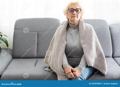 Portrait Of Smiling Mature Woman Holding Walking Stick And Sitting On