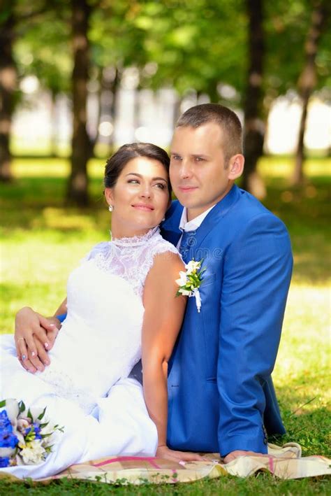 La Novia Y El Novio Felices En Su Boda Se Sienta En La Hierba En Parque