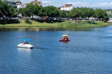 Two People Rowing Their Boats In A Lake Under An Umbrella Editorial