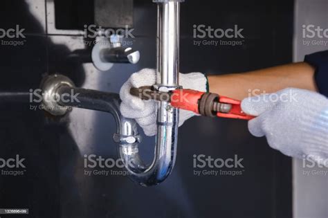 Plumber Fixing White Sink Pipe With Adjustable Wrench Stock Photo