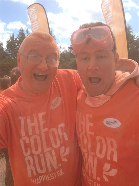 Two Men In Orange Shirts With Their Arms Around Each Other