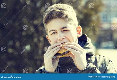 Young Guy Eating A Cheeseburger Stock Photo Image Of Cheeseburger