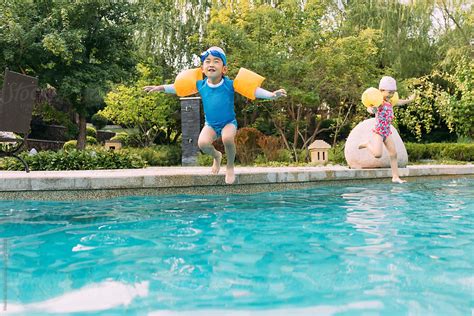 «Two Kids Jumping Into Swimming Pool» del colaborador de Stocksy «MaaHoo» - Stocksy