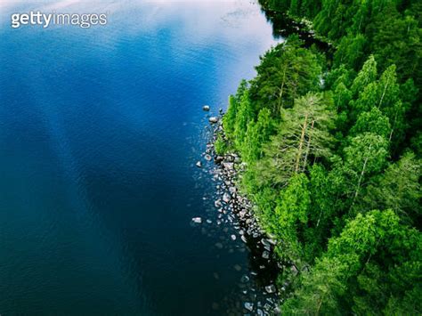 Aerial View Of Blue Lake With Stone Coast And Green Tree Forests On A