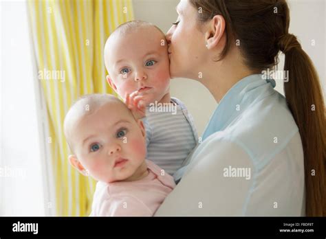 Mother Kissing Twin Babies Stock Photo Alamy