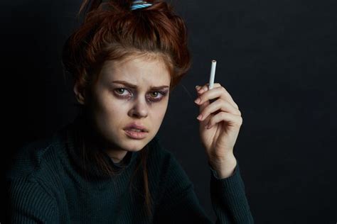 Premium Photo Close Up Of Young Woman Holding Cigarette Against Black