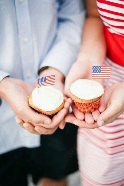 Two People Holding Cupcakes With American Flags On Them