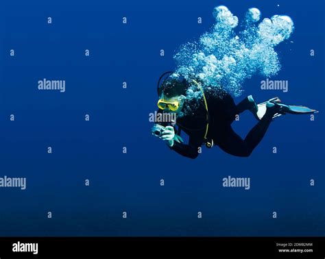 Recreational Scuba Diver With Yellow Mask Cloud Of Bubbles In Black