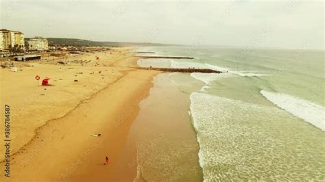 Aerial View Of Ocean With Rocky Piers And Sandy Beach With