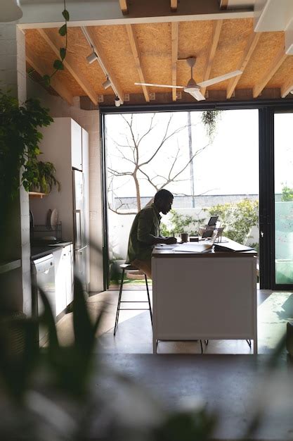 Premium Photo Happy African American Man Sitting At Table In Kitchen