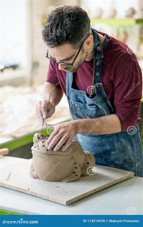 Ceramist Dressed In An Apron Sculpting Statue From Raw Clay In Bright