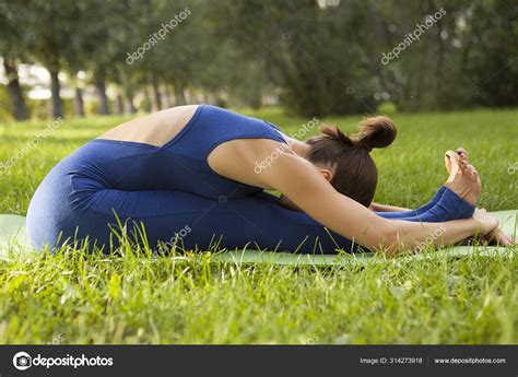 Young Beautiful Girl Practices Yoga Grass Side Stretch Posture Yoga