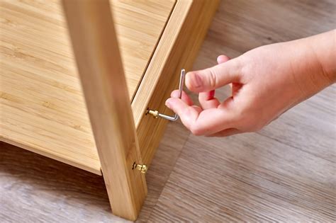 Premium Photo Handyman Is Assembling Flat Pack Furniture Using Screws