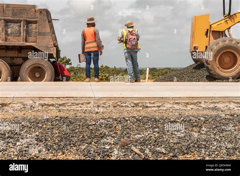 Two Latino Blue Collar Workers Supervising The Construction Of A