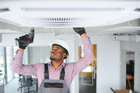 Premium Photo African Male Technician Repairing Air Conditioner