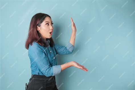 Premium Photo Shocked Asian Woman Wearing Blue Shirt Pointing At The Copy Space Beside Her