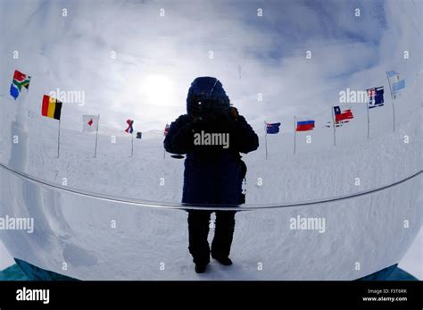 Flags of original signatory nations of the Antarctic Treaty and the photographer reflected at ...