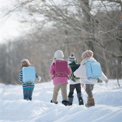 雪道を歩く小学生の後姿の写真素材 Fyi04556877 ストックフォトのamanaimages Plus