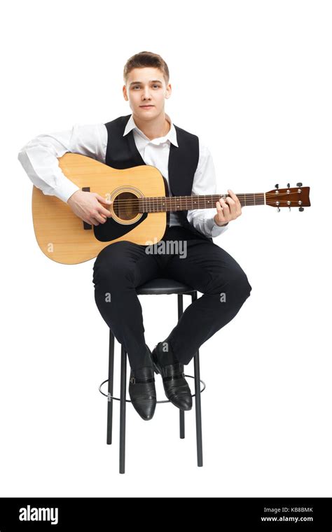 Young Man Playing On Acoustic Guitar Sitting On A Chair Isolated On