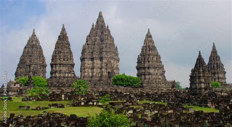 Ancient Stone Ruins On Green Field And Candi Prambanan Or Rara