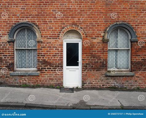 White Front Door And Windows Of A Typical Old Brick British Terraced