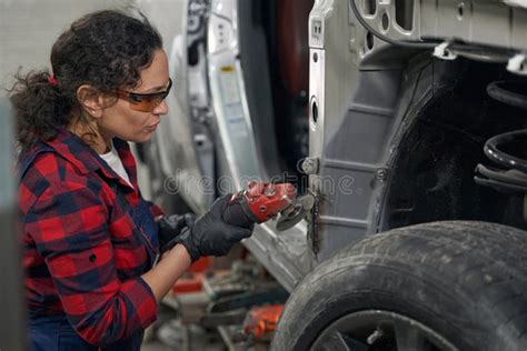 Female Auto Mechanic Repairing Car At Repair Service Station Stock