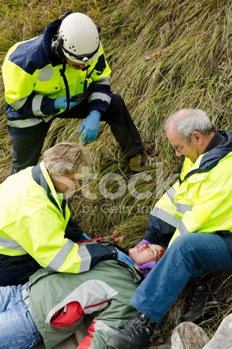 Paramedics Helping An Injured Women On The Mountain Stock Photo