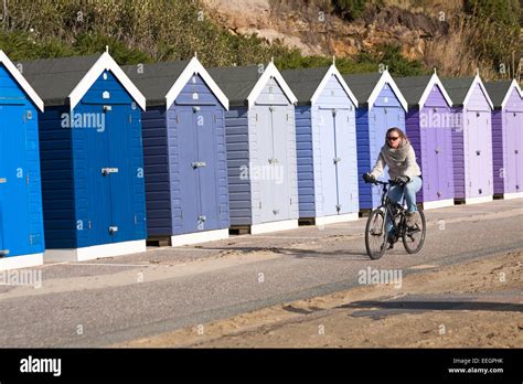 Cycling Along Promenade Past Shades Of Purple Blue Beach Huts At