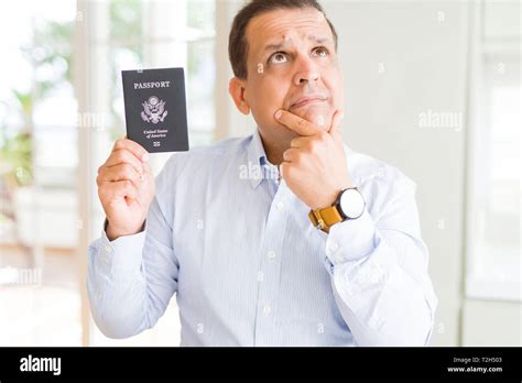 Middle Age Man Holding Holding Passport Of United States Serious Face Thinking About Question