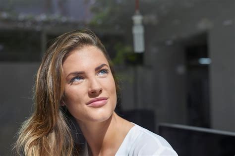 Mujer Joven Sonriente Mirando Por La Ventana Foto Premium