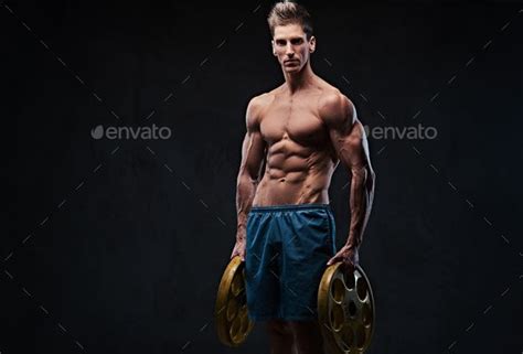 A Shirtless Man Holding Two Dumbs In His Hands Stock Photo Images