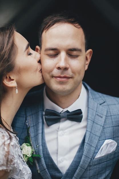 Premium Photo Stylish Bride Kissing Happy Groom In Cheek On