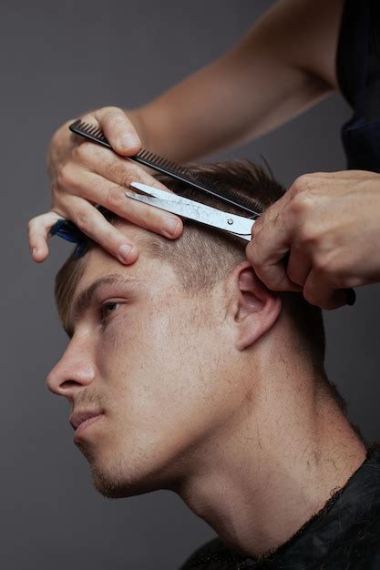 Corte de cabelo masculino tendência na barbearia tesoura e escova