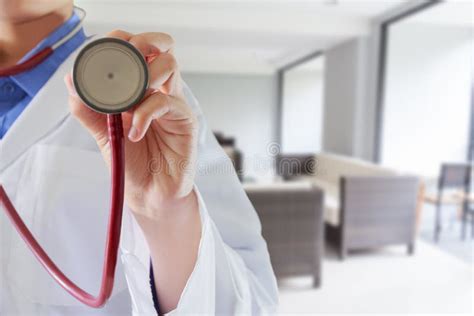 Woman Doctor Listening To Heartbeat With Stethoscope In Hospital Stock